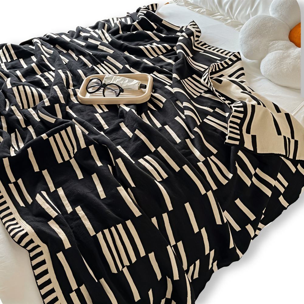 Strikket plaid i sort og beige akryl til sofa og seng