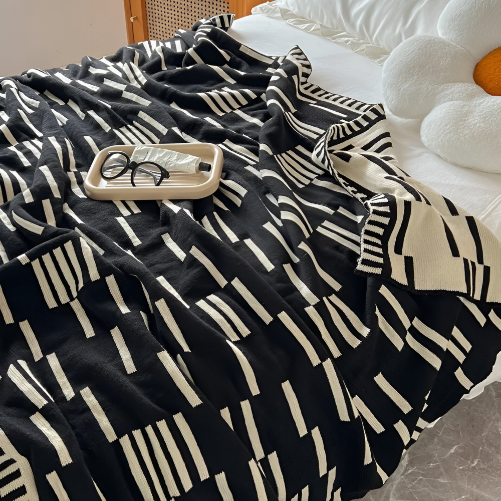 Strikket plaid i sort og beige akryl til sofa og seng