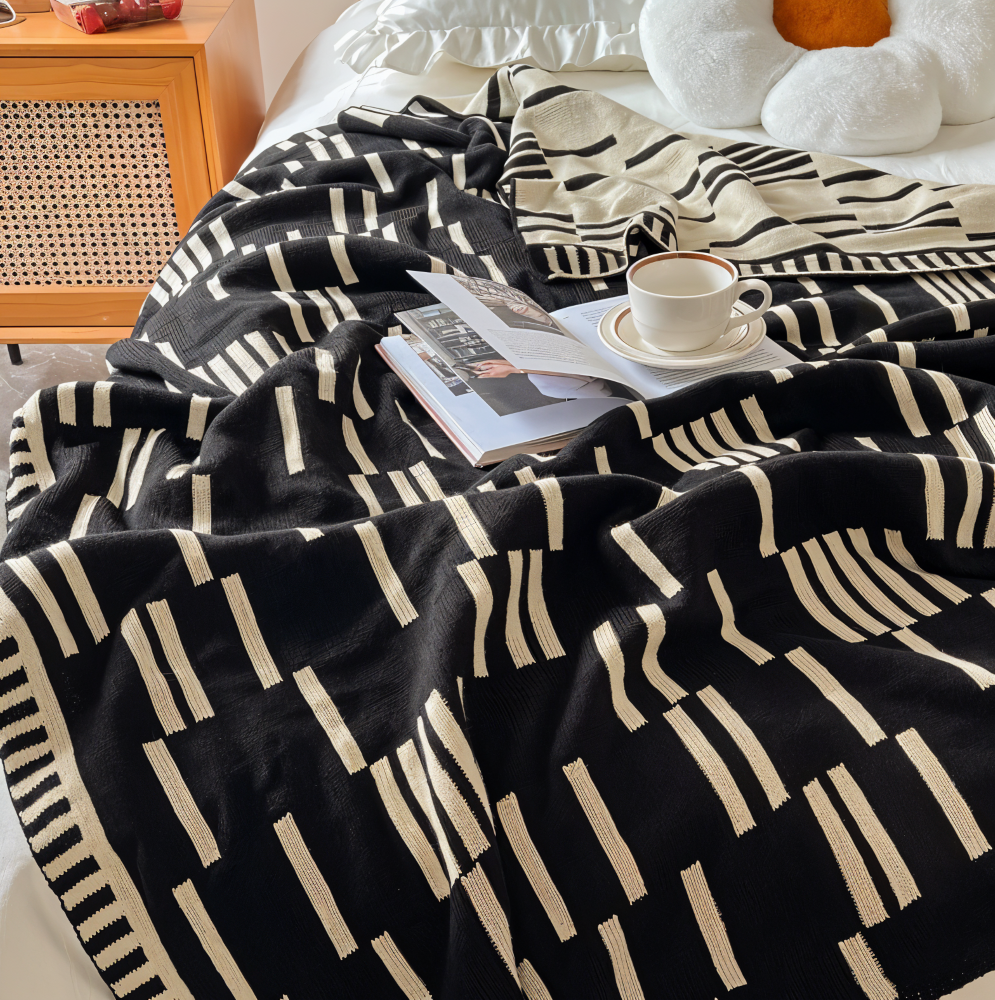 Strikket plaid i sort og beige akryl til sofa og seng