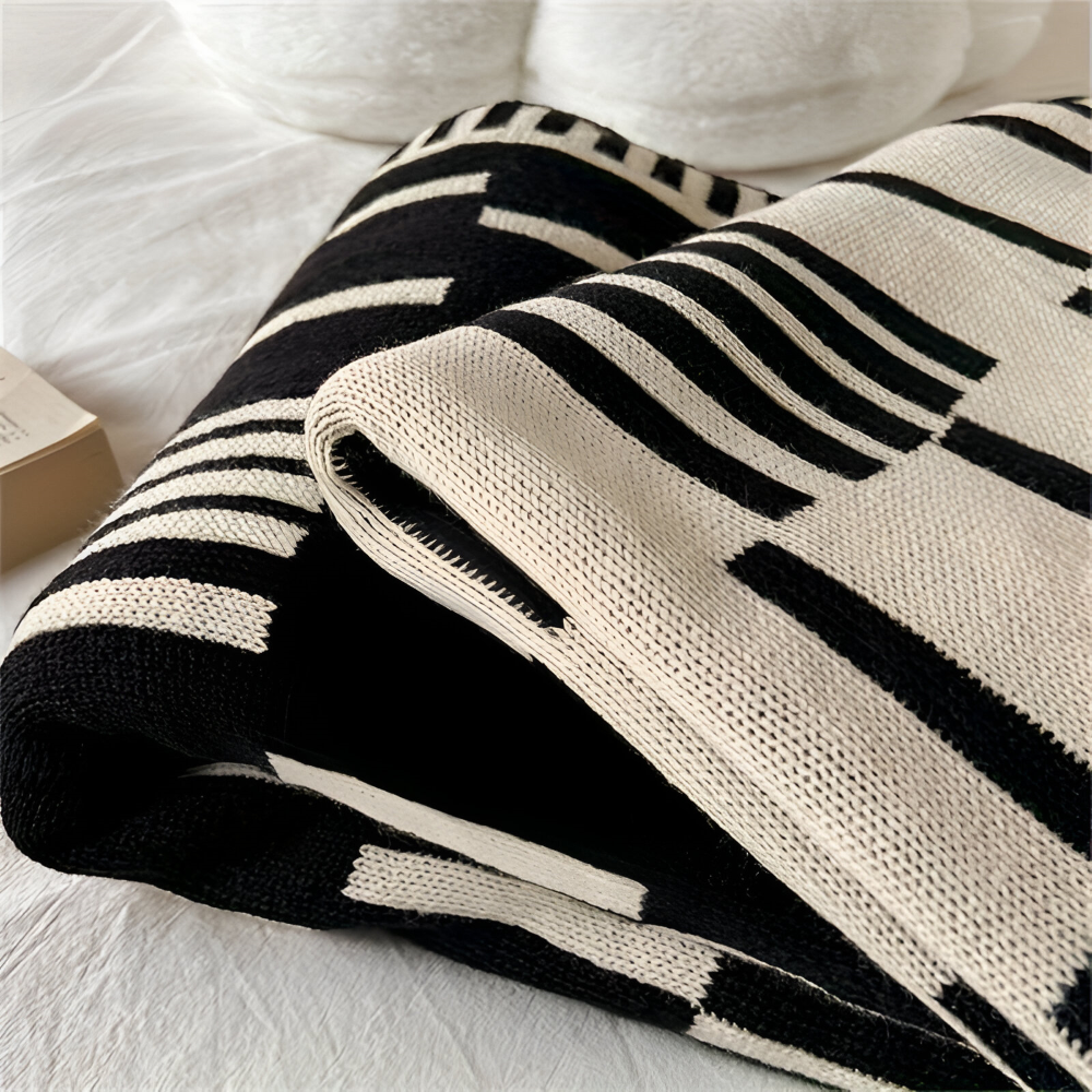 Strikket plaid i sort og beige akryl til sofa og seng