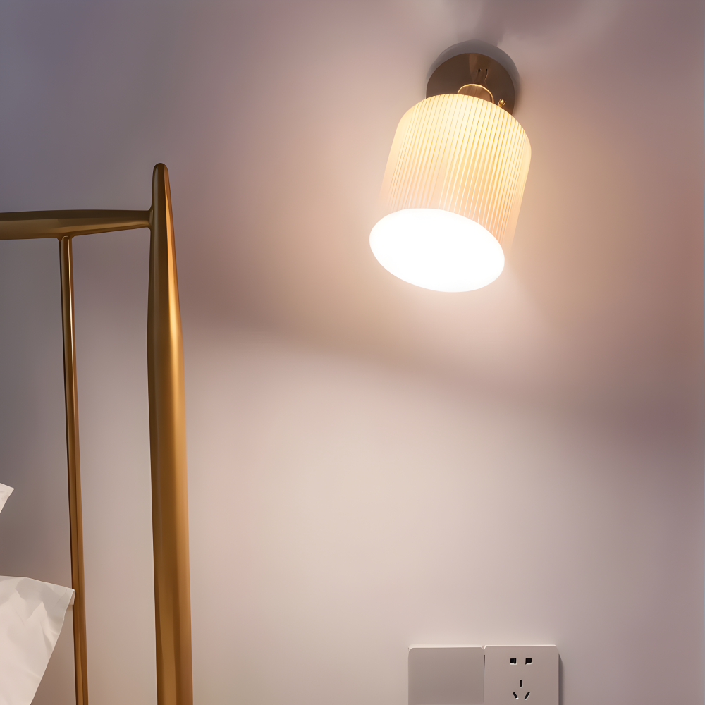 Væglampe i riflet keramik – hvid design med guldbase