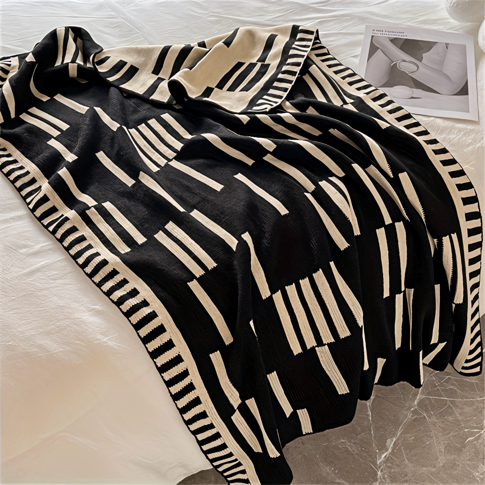 Strikket plaid i sort og beige akryl til sofa og seng