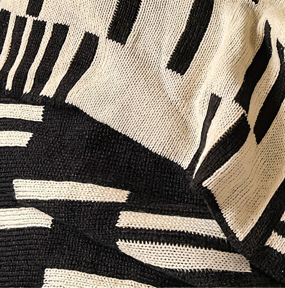 Strikket plaid i sort og beige akryl til sofa og seng