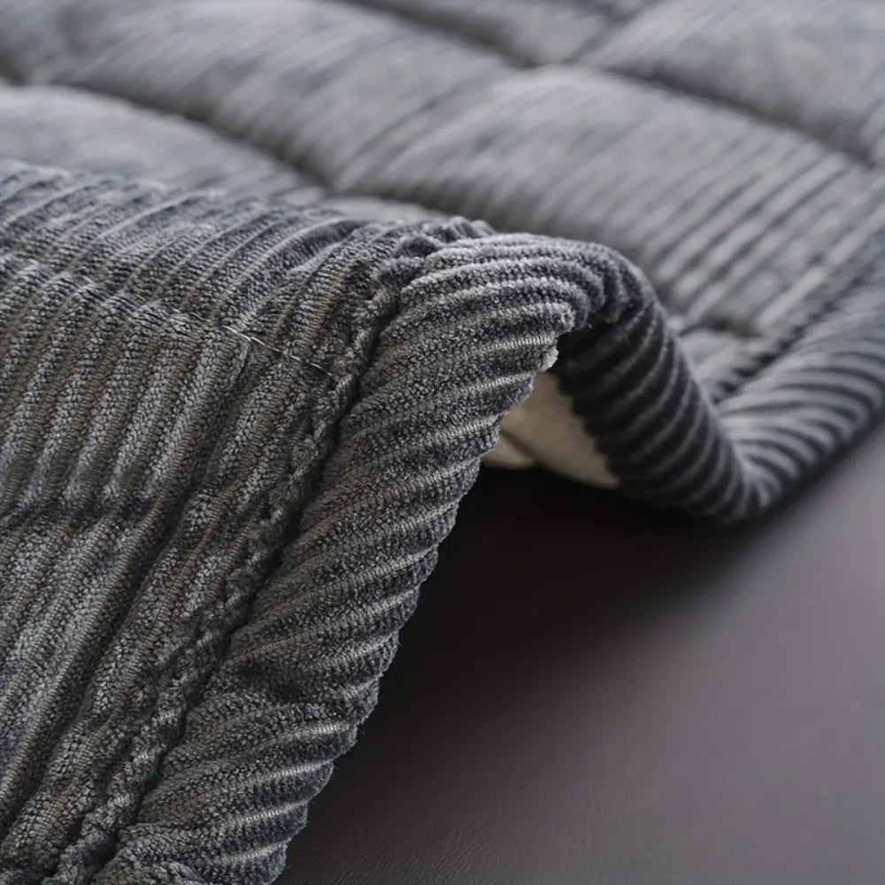 Quiltet sofaovertræk med moderne linjemønster